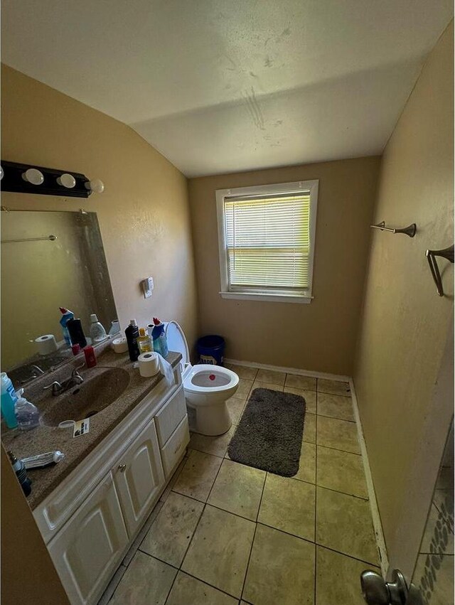 7248 W Potomac Ave, Milwaukee, WI 53216 - bathroom with toilet, vanity, vaulted ceiling, tile patterned floors, and baseboards