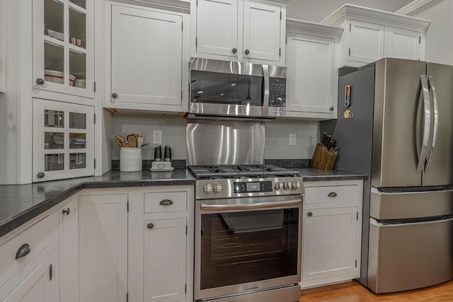 220 Grove St, Ridgeway, WI 53582 - kitchen featuring appliances with stainless steel finishes, glass insert cabinets, light wood-style flooring, and white cabinetry