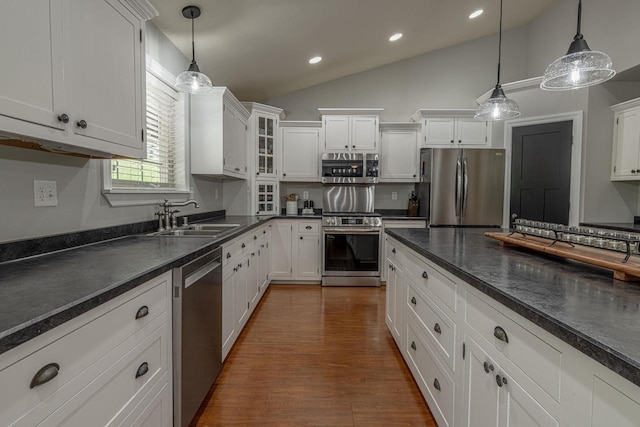 220 Grove St, Ridgeway, WI 53582 - kitchen with stainless steel appliances, a sink, dark countertops, lofted ceiling, and white cabinetry
