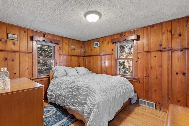 2901 W Forest Hill Ave, Franklin, WI 53132 - bedroom with wood finished floors, a textured ceiling, and wood walls