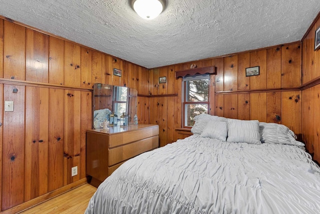 2901 W Forest Hill Ave, Franklin, WI 53132 - bedroom with light wood finished floors, a textured ceiling, and wood walls