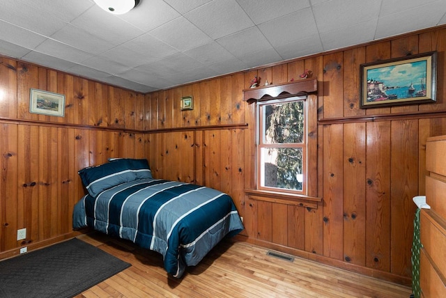 2901 W Forest Hill Ave, Franklin, WI 53132 - bedroom with light wood-style floors, wood walls, and baseboards