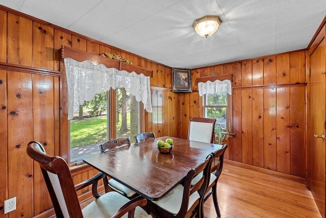 2901 W Forest Hill Ave, Franklin, WI 53132 - dining room featuring wood walls, light wood-style flooring, and baseboards