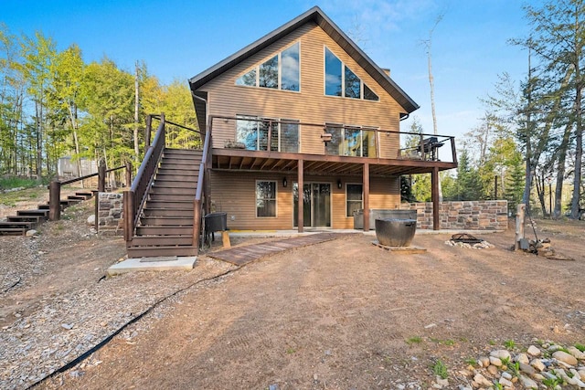 W6554 Wolf Lake Rd, Wausaukee, WI 54177 - rear view of house featuring stairs, a wooden deck, and an outdoor fire pit