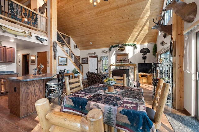 W6554 Wolf Lake Rd, Wausaukee, WI 54177 - dining room with wooden ceiling, high vaulted ceiling, wood finished floors, stairway, and a fireplace