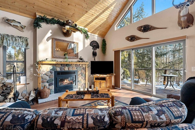 W6554 Wolf Lake Rd, Wausaukee, WI 54177 - living area featuring wood ceiling, high vaulted ceiling, wood finished floors, plenty of natural light, and a stone fireplace