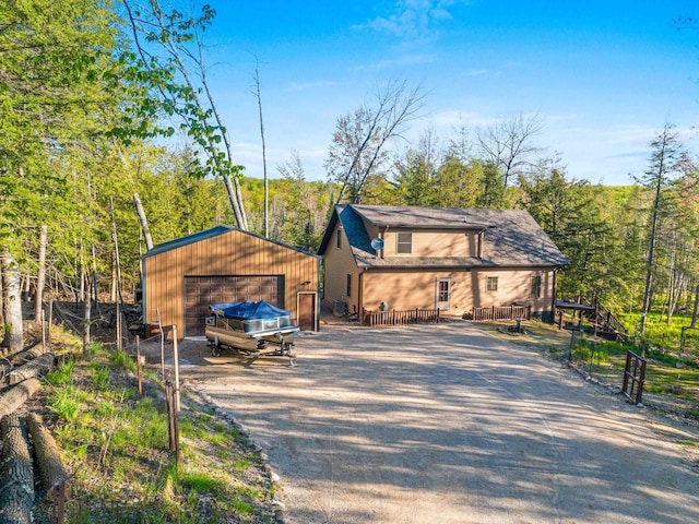 W6554 Wolf Lake Rd, Wausaukee, WI 54177 - view of front of property featuring a garage, an outbuilding, asphalt driveway, and a deck