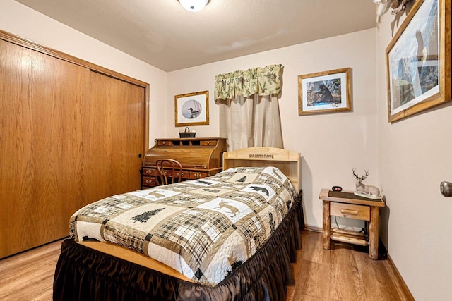 W6554 Wolf Lake Rd, Wausaukee, WI 54177 - bedroom featuring light wood-type flooring, a closet, and baseboards