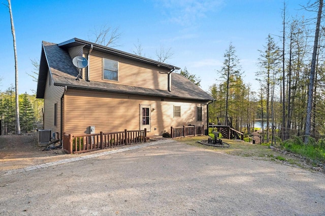 W6554 Wolf Lake Rd, Wausaukee, WI 54177 - view of front facade with a wooden deck and central AC unit