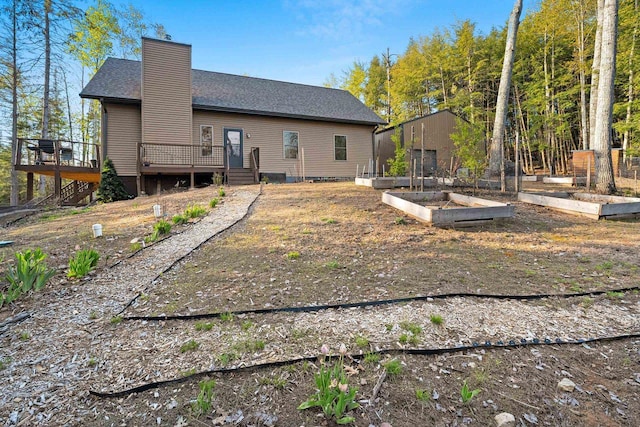 W6554 Wolf Lake Rd, Wausaukee, WI 54177 - rear view of house with a vegetable garden, a chimney, and a deck