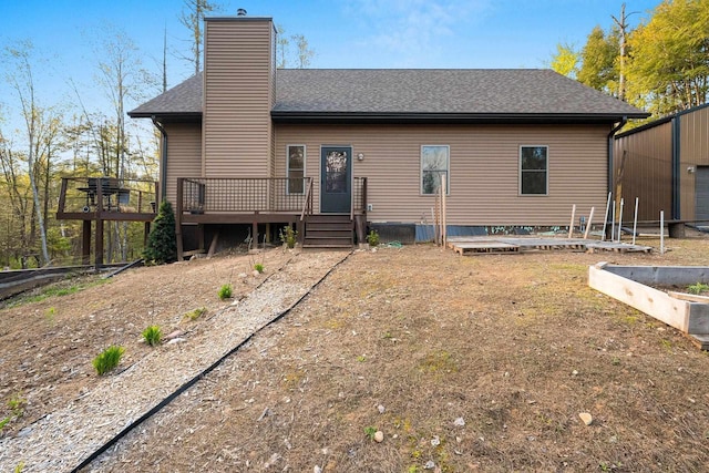 W6554 Wolf Lake Rd, Wausaukee, WI 54177 - back of property featuring a deck, a chimney, roof with shingles, and a garden