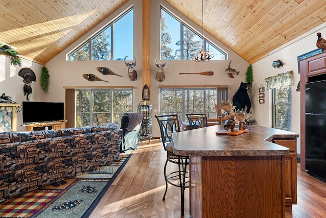 W6554 Wolf Lake Rd, Wausaukee, WI 54177 - kitchen with open floor plan, freestanding refrigerator, high vaulted ceiling, dark countertops, and wood ceiling