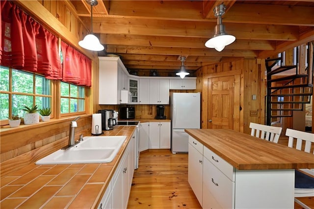 2706 28 1/8 St, Birchwood, WI 54817 - kitchen featuring freestanding refrigerator, tile counters, a sink, beamed ceiling, and white cabinetry