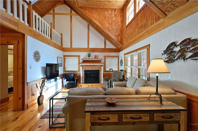 2706 28 1/8 St, Birchwood, WI 54817 - living area with high vaulted ceiling, light wood-style flooring, a tile fireplace, and a textured wall