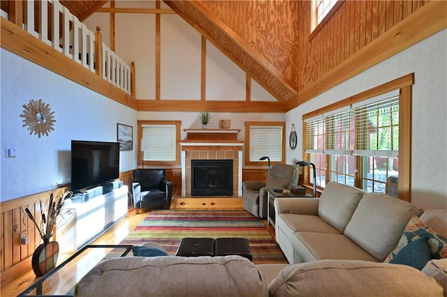 2706 28 1/8 St, Birchwood, WI 54817 - living room with high vaulted ceiling, a tile fireplace, wood finished floors, a textured wall, and a wainscoted wall