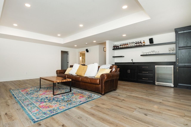 W329N6597 Forest Dr, Hartland, WI 53029 - living room featuring beverage cooler, wet bar, a tray ceiling, light wood-style floors, and recessed lighting