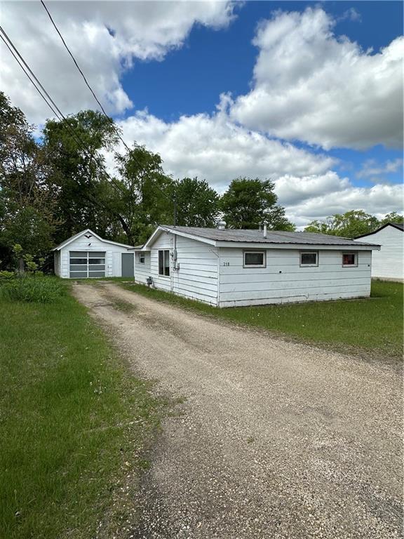 218 Meade Ave, Black River Falls, WI 54615 - view of front facade with dirt driveway, a garage, and an outdoor structure