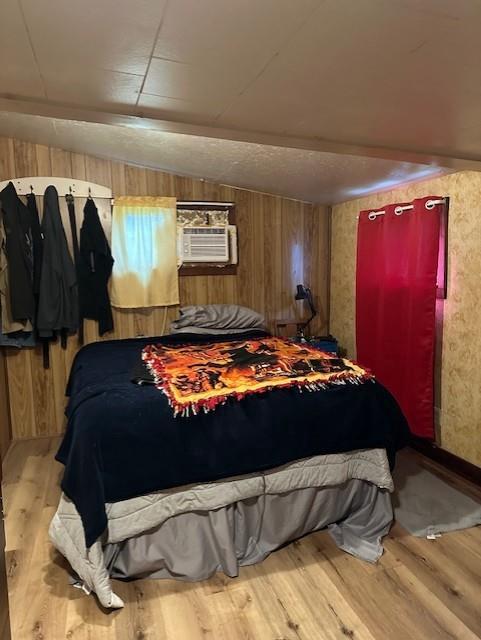 218 Meade Ave, Black River Falls, WI 54615 - bedroom featuring wood finished floors, a wall mounted air conditioner, and wooden walls