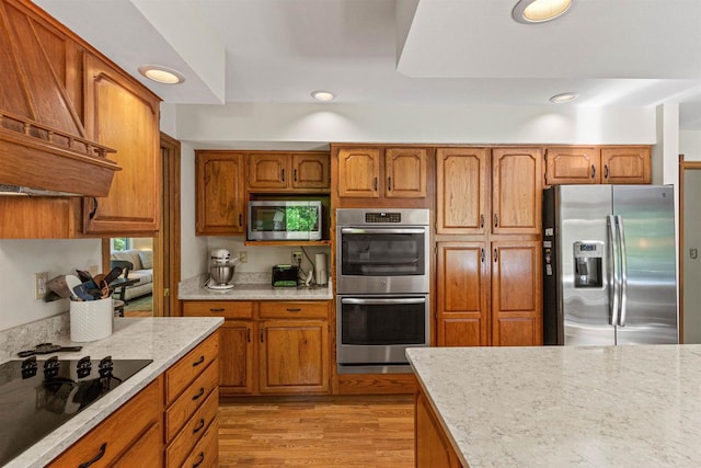 N1124 County Rd E, Waupaca, WI 54981 - kitchen featuring stainless steel appliances, custom range hood, brown cabinets, light wood-style flooring, and recessed lighting