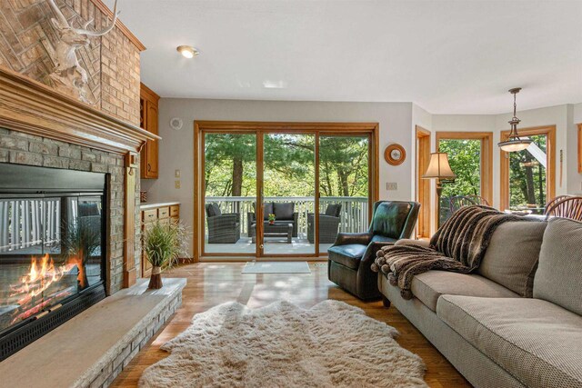 N1124 County Rd E, Waupaca, WI 54981 - living area featuring a brick fireplace and light wood finished floors