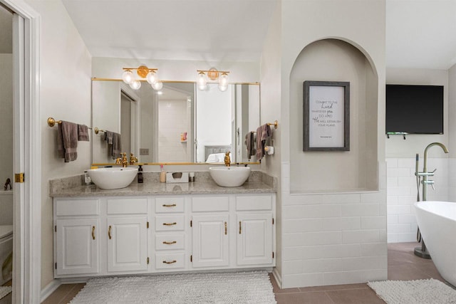 N1124 County Rd E, Waupaca, WI 54981 - full bathroom featuring double vanity, a freestanding bath, tile patterned floors, tile walls, and wainscoting