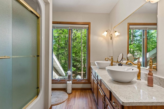 N1124 County Rd E, Waupaca, WI 54981 - bathroom featuring double vanity, an enclosed shower, wood finished floors, and baseboards