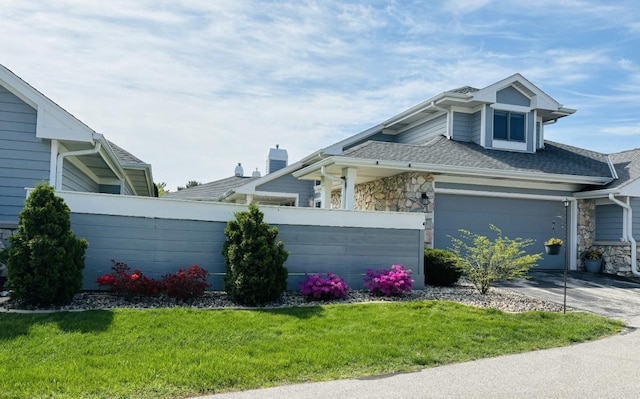 14048 W Waters Edge Trl, New Berlin, WI 53151 - view of front facade with driveway, stone siding, an attached garage, and a shingled roof
