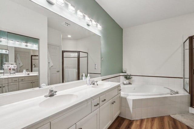 14048 W Waters Edge Trl, New Berlin, WI 53151 - bathroom with wood finished floors, double vanity, a bath, and a stall shower