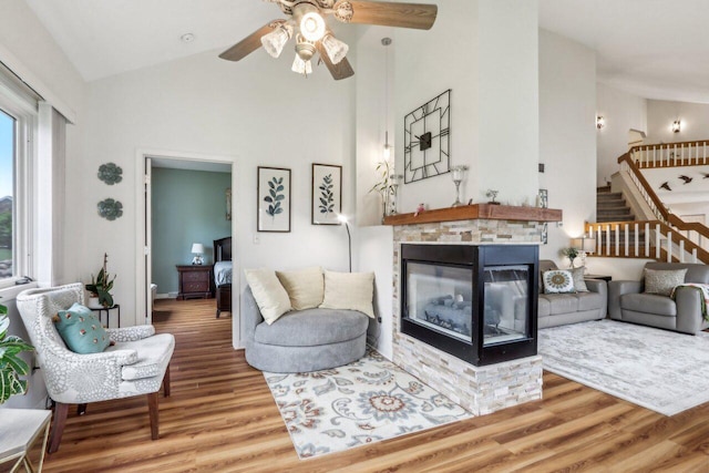 14048 W Waters Edge Trl, New Berlin, WI 53151 - living room featuring a ceiling fan, high vaulted ceiling, wood finished floors, stairs, and a multi sided fireplace