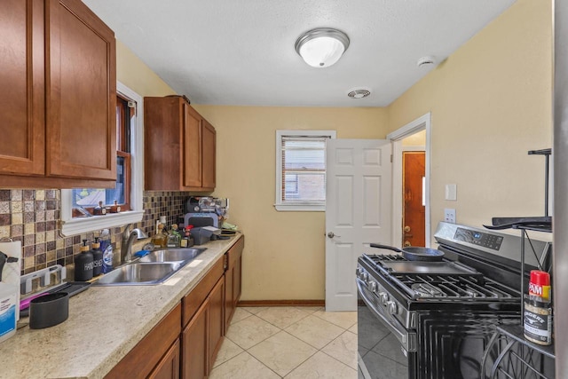 5936 N 35th St, Milwaukee, WI 53209 - kitchen with gas range, tasteful backsplash, a sink, light countertops, and baseboards