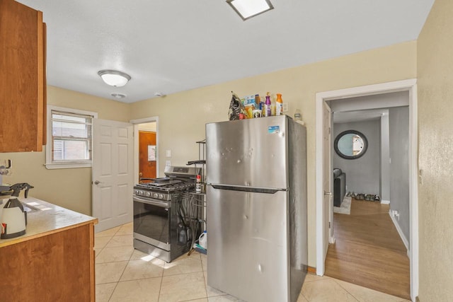 5936 N 35th St, Milwaukee, WI 53209 - kitchen with stainless steel appliances, light tile patterned flooring, light countertops, and brown cabinets