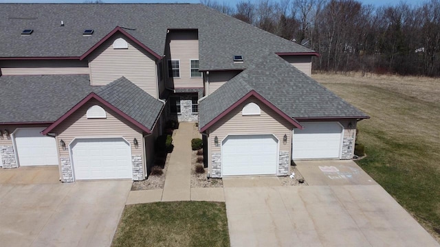 433 Eberlein Ct, Mauston, WI 53948 - view of front of home featuring stone siding, a shingled roof, concrete driveway, a front yard, and a garage