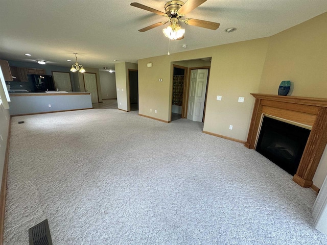 433 Eberlein Ct, Mauston, WI 53948 - unfurnished living room with a fireplace, baseboards, a ceiling fan, light carpet, and a chandelier