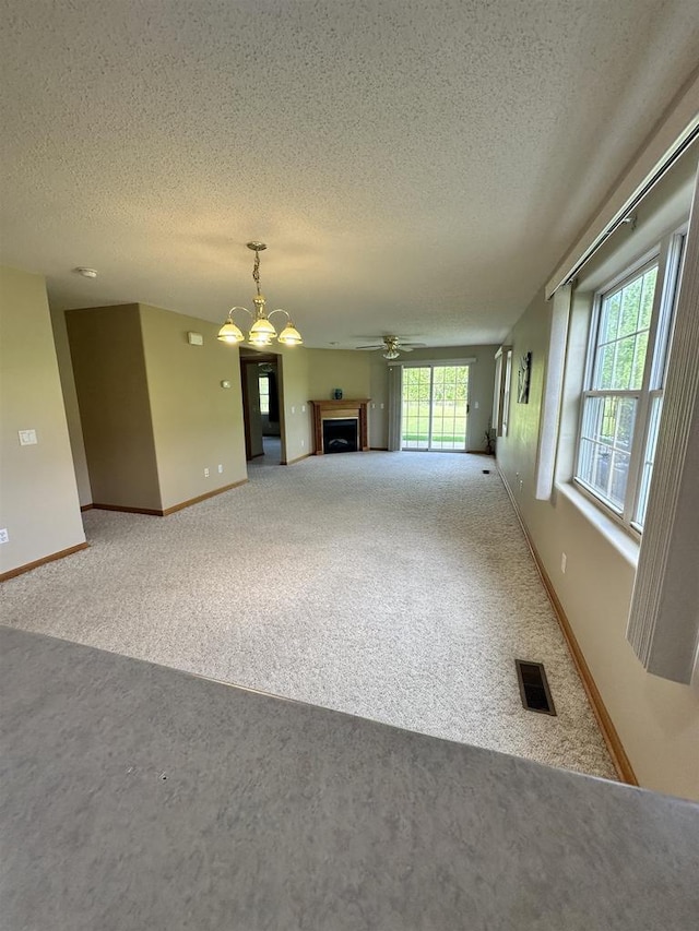433 Eberlein Ct, Mauston, WI 53948 - unfurnished living room with carpet flooring, a textured ceiling, a fireplace, baseboards, and ceiling fan
