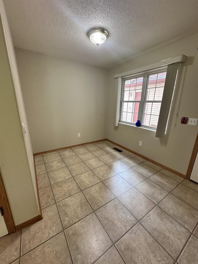 433 Eberlein Ct, Mauston, WI 53948 - unfurnished room featuring a textured ceiling, light tile patterned floors, and baseboards