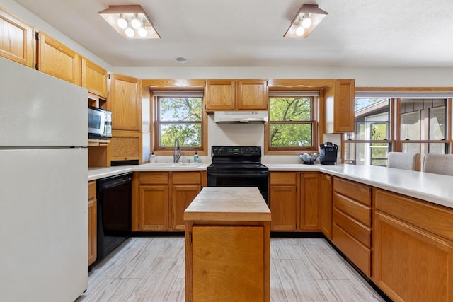 10029 W Spring Rd, Fox Lake, WI 53933 - kitchen with black appliances, a sink, under cabinet range hood, butcher block countertops, and light wood finished floors