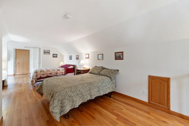 10029 W Spring Rd, Fox Lake, WI 53933 - bedroom featuring lofted ceiling, light wood-style flooring, and baseboards