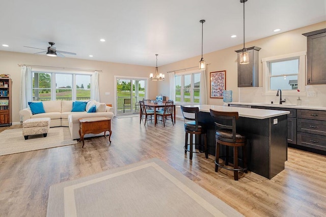 W4936 Battlestone Station Rd, La Crosse, WI 54601 - kitchen featuring a sink, a center island, a chandelier, a breakfast bar, and light countertops