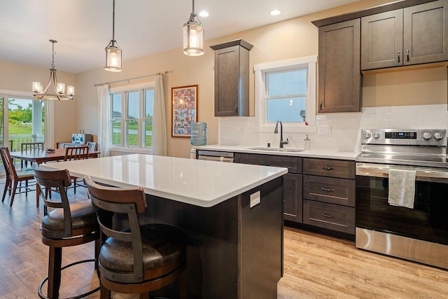 W4936 Battlestone Station Rd, La Crosse, WI 54601 - kitchen featuring appliances with stainless steel finishes, a sink, a kitchen island, light countertops, and tasteful backsplash