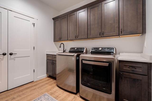 W4936 Battlestone Station Rd, La Crosse, WI 54601 - laundry area with cabinet space, washing machine and dryer, and light wood-style floors