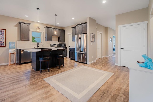 W4936 Battlestone Station Rd, La Crosse, WI 54601 - kitchen featuring appliances with stainless steel finishes, a sink, a center island, light countertops, and a kitchen breakfast bar