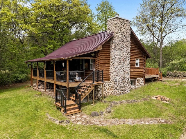 W3276 Princeton Rd, Green Lake, WI 54941 - back of property featuring log siding, a chimney, a yard, and a deck