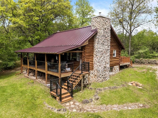 W3276 Princeton Rd, Green Lake, WI 54941 - back of property featuring log exterior, a chimney, a lawn, metal roof, and a wooden deck