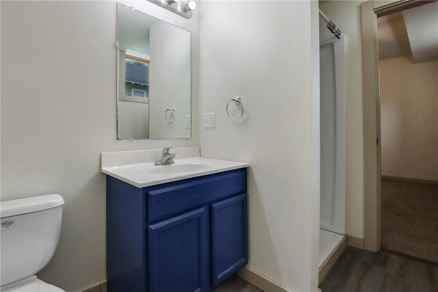 324 Douglas St, Chetek, WI 54728 - bathroom featuring a shower stall, vanity, toilet, wood finished floors, and baseboards
