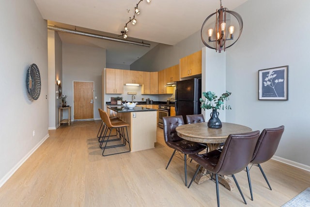 1924 N Hubbard St Unit 208, Milwaukee, WI 53212 - dining area with high vaulted ceiling, light wood-style floors, baseboards, and a chandelier
