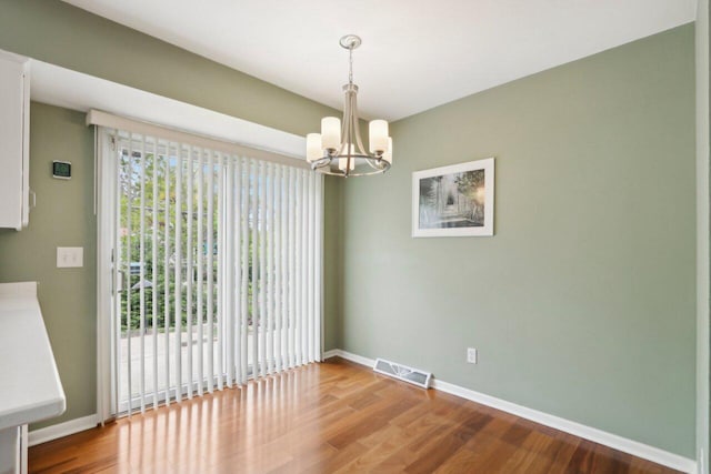 620 S Greenfield Ave, Waukesha, WI 53186 - unfurnished room with a chandelier, wood finished floors, and baseboards
