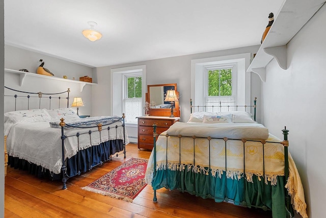 4105 Lime Kiln Rd, Green Bay, WI 54311 - bedroom featuring multiple windows, wood-type flooring, and a baseboard heating unit