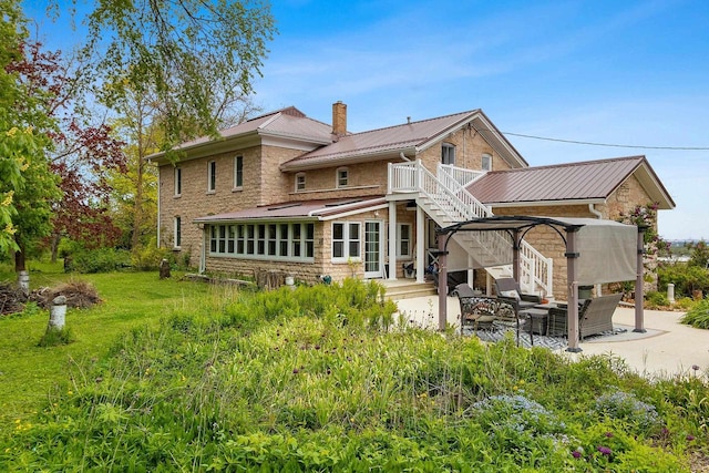 4105 Lime Kiln Rd, Green Bay, WI 54311 - rear view of property with a patio area, stairs, metal roof, a chimney, and outdoor lounge area