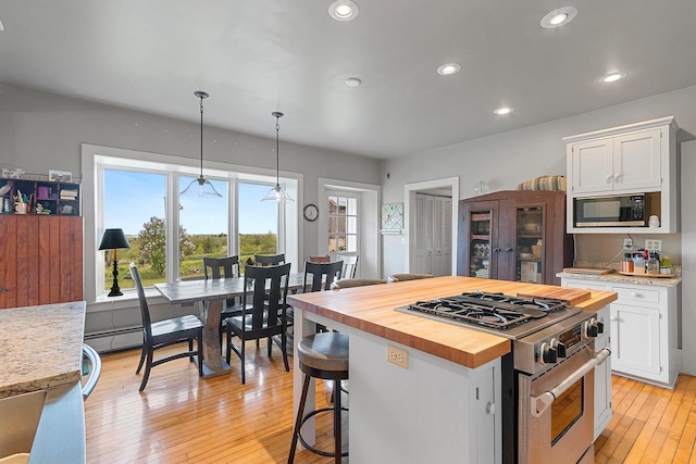 4105 Lime Kiln Rd, Green Bay, WI 54311 - kitchen with high end stainless steel range, wood counters, built in microwave, white cabinets, and recessed lighting