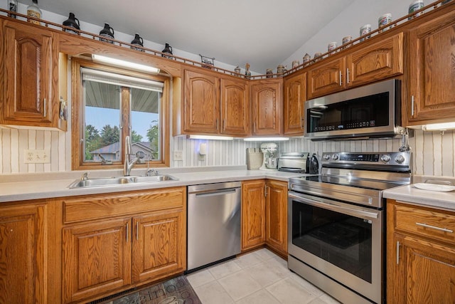223 Willow Creek Rd, Rosendale, WI 54974 - kitchen featuring stainless steel appliances, a sink, light countertops, brown cabinets, and lofted ceiling